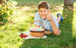 © Natali - Happy Easter! Cute smiling boy teenager in blue shirt holds basket with handmade colored eggs on grass in spring park. Decoration for Easter, celebration, egg hunt in the garden