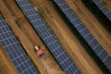 Wall Mural - Aerial tractor when working under the solar photovoltaic panel