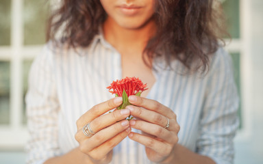 Wall Mural - young beautiful sensual woman with nice manicure holding the person red tropical flowers, natural be