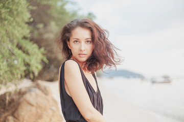 Wall Mural - portrait of a beautiful young woman with dark hair, on the beach, sensual portrait, natural beauty