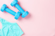 © Lazy_Bear - Blue dumbbells and sport bra on a pink background, top view with copy space. Fitness concept