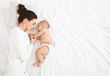 © Prostock-studio - Young mom and her cute baby sleeping in bed