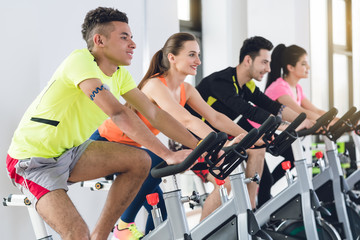 Wall Mural - Group of young friends cycling in row at gym