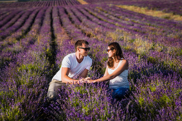 Couple in love on lavender fields. Boy and girl in the flower fields. Honeymoon trip. Honeymoon. Newly married couple. Couple travels. Lavender meadows. Lover. Happy couple. Lover holding hands