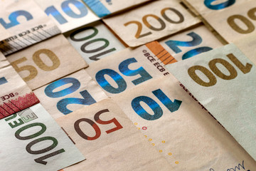 Money and finances concept. Bright colorful abstract surface, background of euro national currency different bills. Banknotes worth ten, twenty, fifty, hundred and two hundred euro.