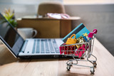 Fototapeta Tęcza - Shopping cart with credit card and woman accessories with laptop, Online shopping concept