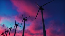 Windmill Farm At Sunset. Silhouette Of A Windmill Against A Red Sky. 3D Rendering
