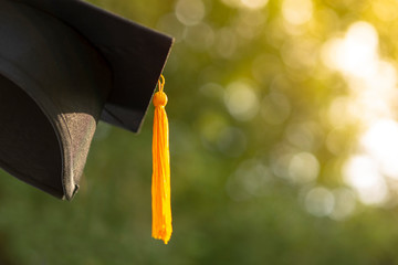 Hat of black graduates Golden yellow tassel Blurred bokeh background