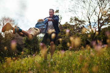 Father swinging his son around in a circle