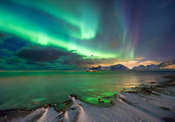 real magic of northern lights - norwegian fjord with snow and mountains