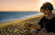 © Akin Ozcan - Young woman playing with her dog on beach in sunset light. Stylish girl / female having fun with funny dog. Cute moments on summer day vacation. Animal and human friendship, connection, trust concept.