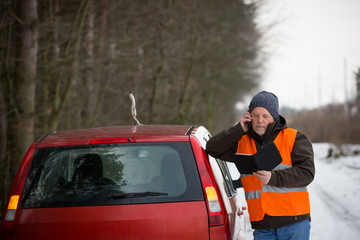 man calling the roadside service / assistance after his car has broken down, car problem concept during winter time