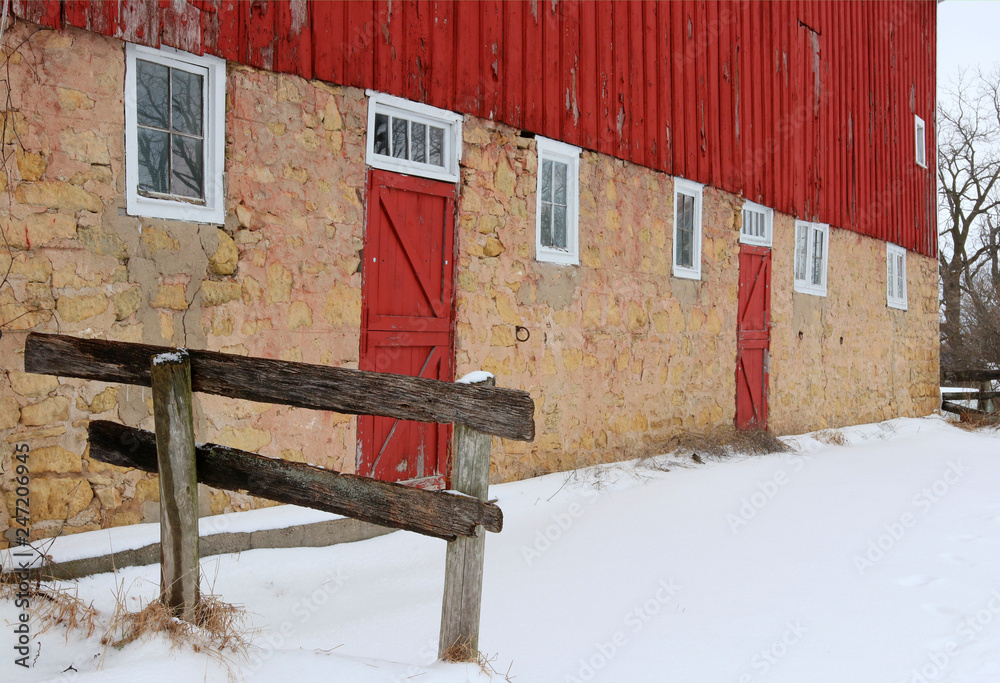 Snowy winter view with old red barn. Old style stoned red barn and yard ...