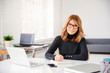 © sepy - Businesswoman sitting at office desk and doing some paperwork