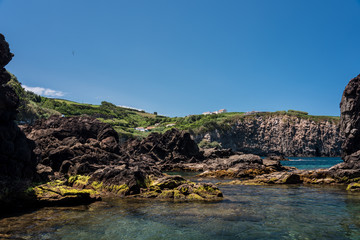 Wall Mural - natural pool  in terceria, view of the rocky seaside in terceira with natural pool to have a bath, seascape in azores, portugal.