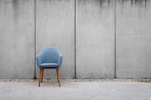 Empty Chair With Concrete Wall Background On Sidewalk