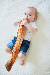 Wall Mural - Six months old baby girl eating bread