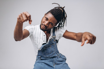 Wall Mural - African American on a white background in jeans and a white T-shirt, emotions, emotional person