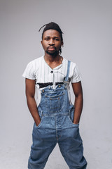 Wall Mural - African American on a white background in jeans and a white T-shirt, emotions, emotional person