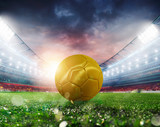 Fototapeta Sport - Golden Soccerball at the stadium ready for match