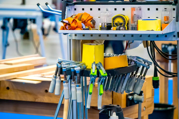 Poster - Tool for carpentry work. Rack with the tool. Joiner's clamp. Saw on a tree. Carpenter work.