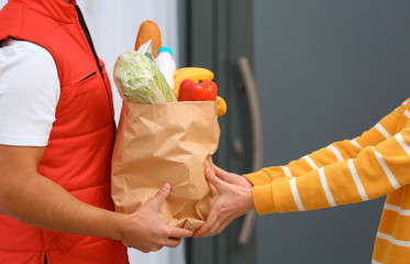 Male courier delivering food to client indoors, closeup