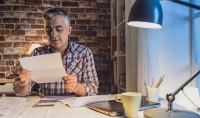 Worried man checking his domestic bills at home