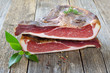 Südtiroler Speck am Stück: Eine Hamme in zwei Hälften geteilt auf einem Holztisch – Typical South Tyrolean bacon divided into two halfes lying on a rustic table