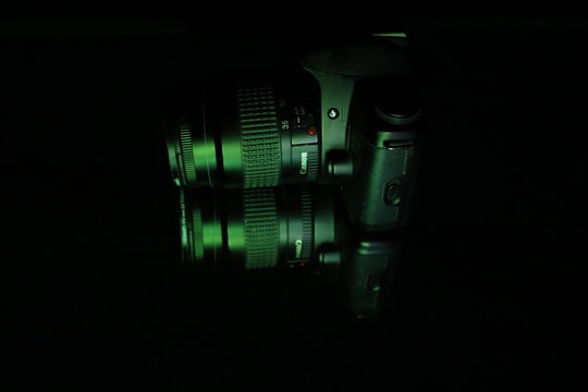 abstract background and camera Canon with lots of green light spots 