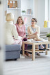 © Seventyfour - Full length portrait of three adult women enjoying conversation during family evening at home, copy space