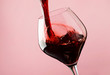 French dry red wine, pours into glass, trendy pink background, space for text, selective focus