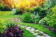 beautiful summer cottage garden view with stone pathway and blooming perennials