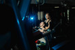 © combo1982 - Active beautiful fitness model girl helps young man to train on the block simulator in the gym.