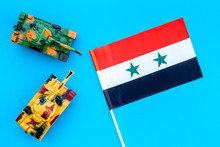 War, Military Threat, Military Power Concept. Syria. Tanks Toy Near Syrian Flag On Blue Background Top View