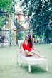 girl in red swimsuit sitting on white sunbed