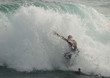 Surfista in azione mentre viene coperto dall' onda del mare