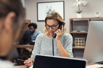 businesswoman talking on phone at office