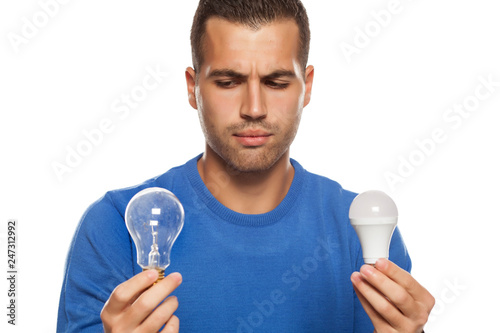Portrait Of Young Man Holding Led Bulb And Old Fachion Bulb On