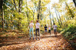 © dusanpetkovic1 - Small group of happy friends running in the woods in the autumn.