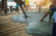Workers Pour The Cement For The Construction Of A Residential Building Using Mobile Concrete Mixers.