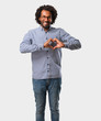 © Asier - Handsome business african american man making a heart with hands, expressing the concept of love and friendship, happy and smiling