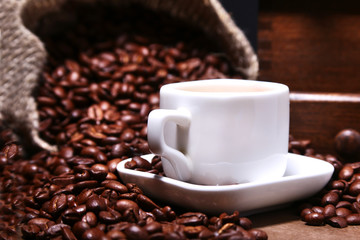 Wall Mural - Fresh roasted coffee beans in burlap sack, espresso in cup and grinder on stone background.