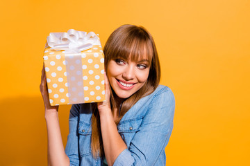 Poster - Close up portrait of attractive beautiful she her lady holding large giftbox in hands glad ready to unpack it wearing casual jeans denim shirt clothes isolated on yellow background