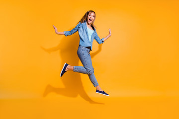 Full length body size photo yelling  jumping high beautiful she her lady little low prices announce black friday shopping store wearing casual jeans denim shirt clothes isolated on yellow background