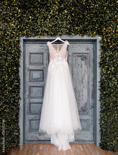 Cuadros en Lienzo White wedding dress of bride hangs on background of door, boho and rustic style