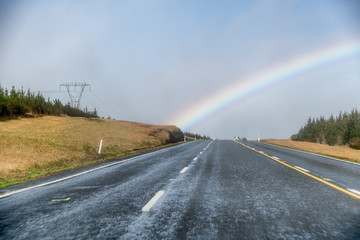 Canvas Print - Countryside road with rainbow. Holiday and travel concept