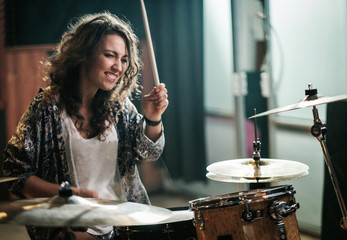 Wall Mural - Woman playing drums during music band rehearsal