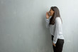 © Asier - Young indian woman against a grunge wall screaming angry, expression of madness and mental instability, open mouth and half-opened eyes, madness concept
