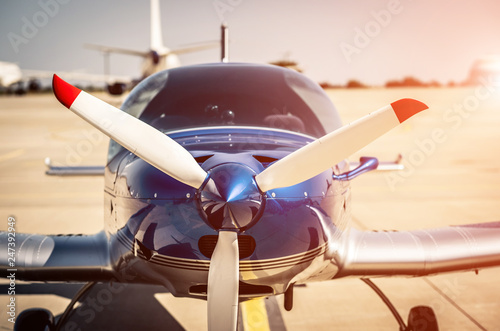 Cuadros en Lienzo Shiny blue sport plane at the airport sunshine runway