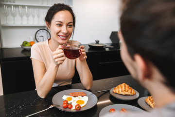 Wall Mural - Loving couple indoors in home at kitchen have a breakfast drinking tea.